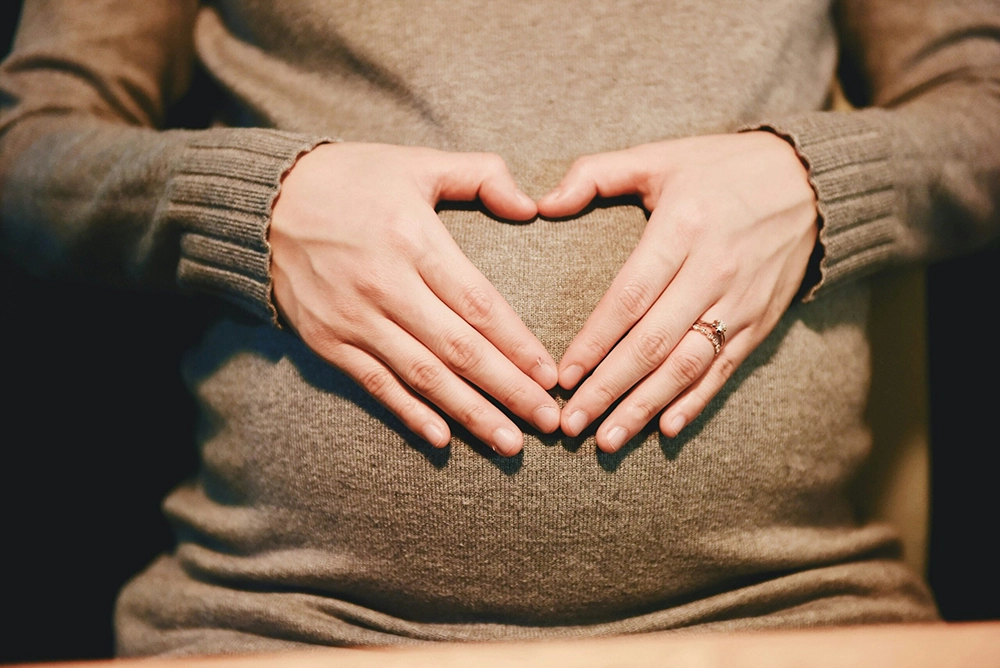 Mother with heart symbol on belly